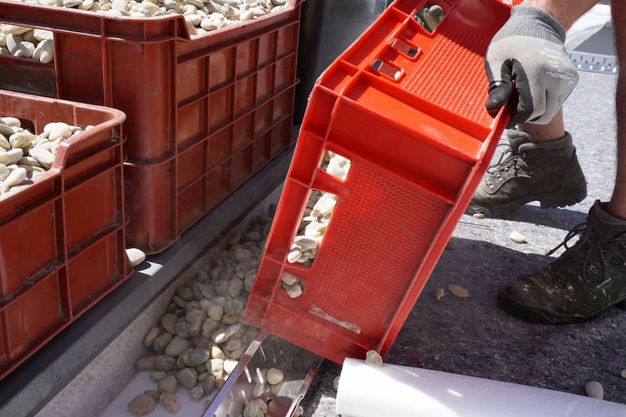 Sypání kačírku po okrajích extenzivní zelené střechy jako hydroizolační vrstvy